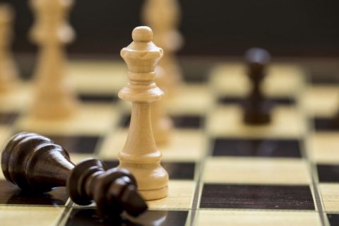 Foto: Esin Deniz / shutterstock Schachbrett mit einem querliegenden schwarzen "König" (Spielfigur) und eine darüber stehenden weißen "Dame" (Spielfigur). Im unscharf gehaltenen Hintergrund befinden sich noch weitere Spielfiguren.